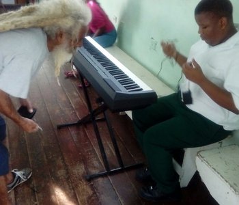 Staff and Students Set up one of the Keyboards generously donated by  Prof. Rajendra Ramlogan
